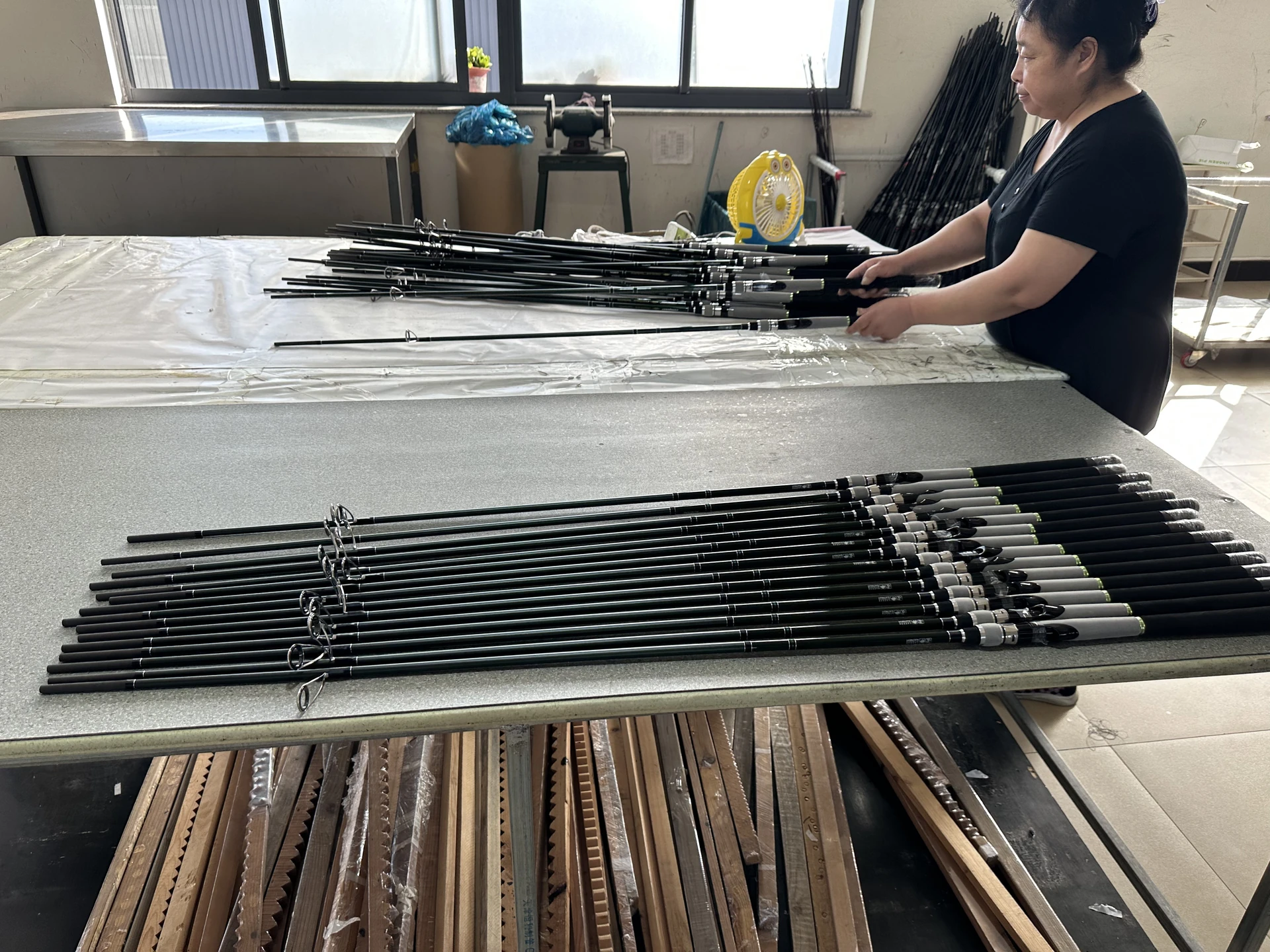 Operator handling fishing rods at the workbench